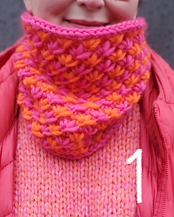 Modell trägt einen pink-orangefarbenen Loop im Sternchenmuster.